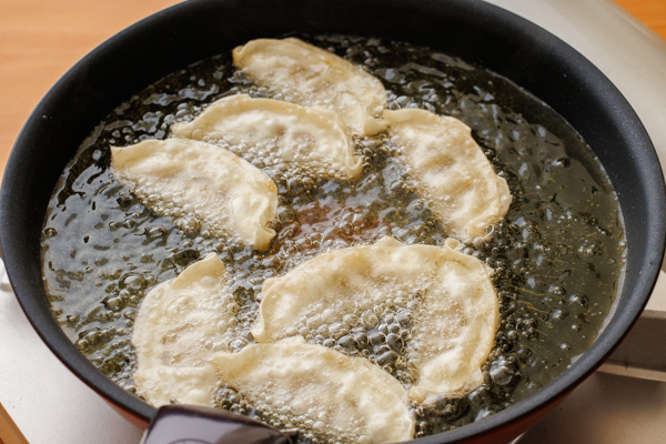 大阪王将 羽根つき餃子を凍ったまま油の中に入れ、中火で約4分揚げる。油を切って器に盛り、お好みでパセリを添える。